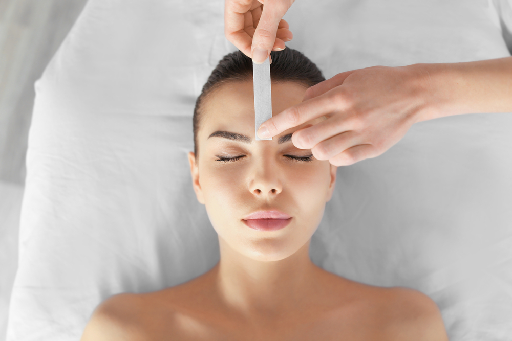 Beautician,Waxing,Young,Woman's,Eyebrows,In,Spa,Center